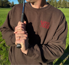 Load image into Gallery viewer, Man holding a golf club on a golf course with trees in the background
